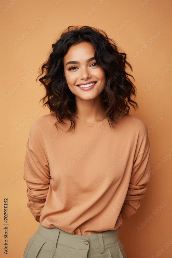 Smiling young woman in beige sweater and skirt looking at camera Smiling young woman in beige sweater and skirt looking at camera