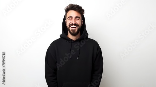 Handsome man in black sweatshirt laughing on a white background