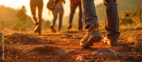 mountain climbing walking in the forest in the sunset light wearing mountain shoes. photo