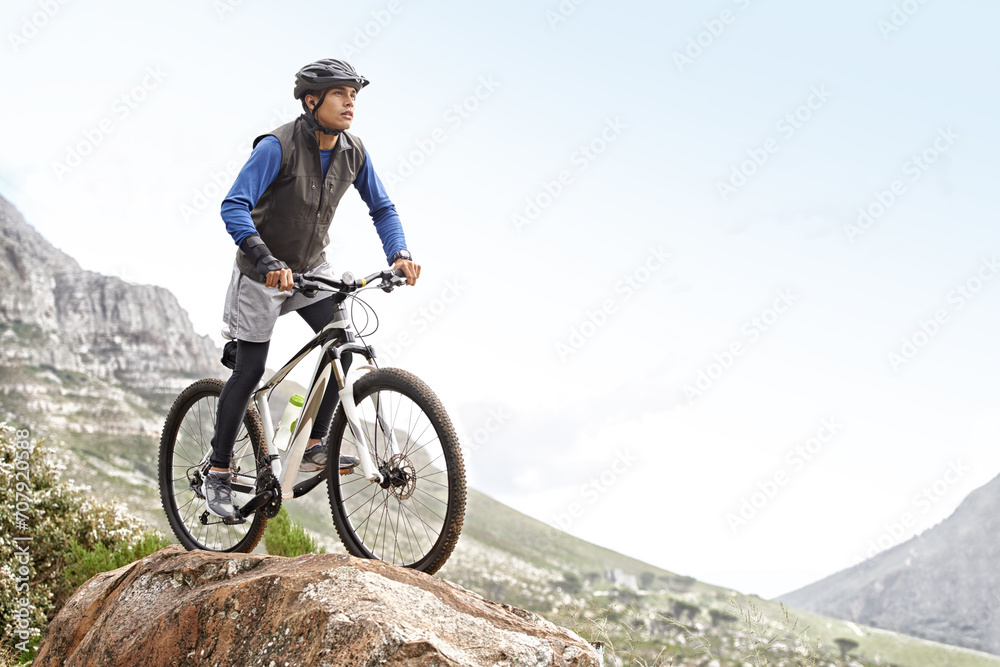 Man, mountain bike and off road cycling with mockup space on nature adventure or fitness in outdoor extreme sport. Male person or cyclist on bicycle for cardio on cliff hill in exercise with blue sky