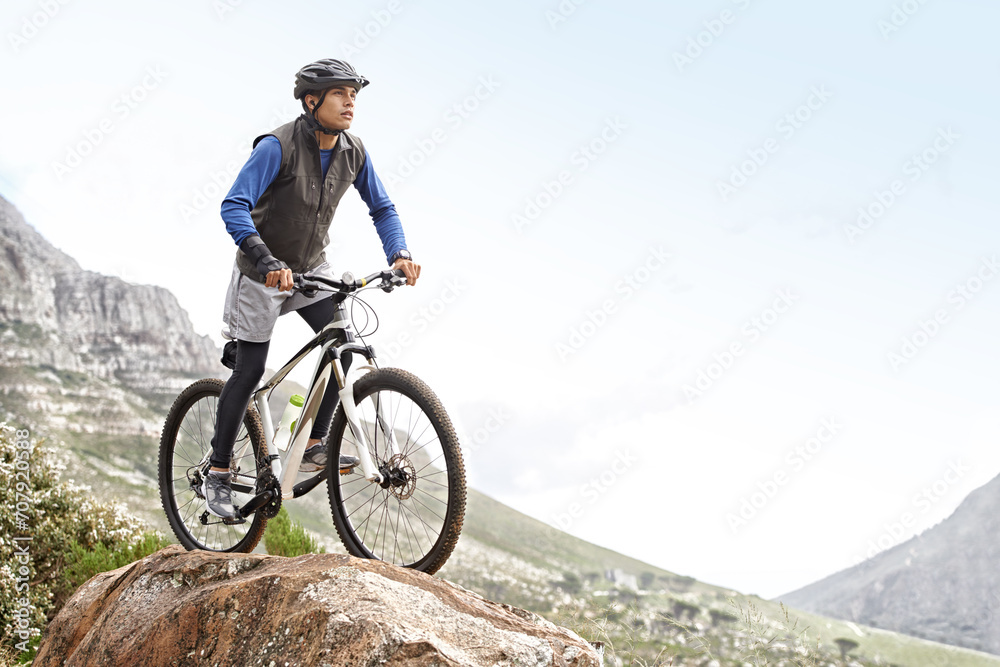 Man, mountain bike and off road cycling with mockup space on nature adventure or fitness in outdoor extreme sport. Male person or cyclist on bicycle for cardio on cliff hill in exercise with blue sky Man, mountain bike and off road cycling with mockup space on nature adventure or fitness in outdoor extreme sport. Male person or cyclist on bicycle for cardio on cliff hill in exercise with blue sky