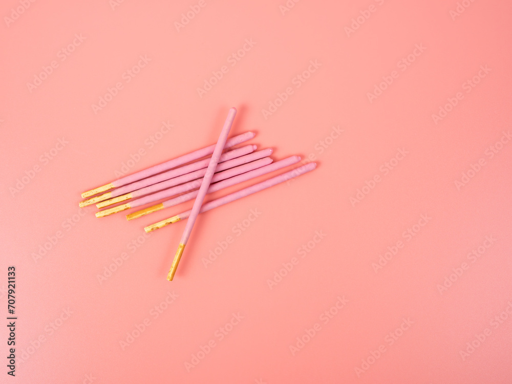 Crispy sticks in pink sugar glaze. Sticks in berry pink glaze on a pink background. Crispy sticks in pink sugar glaze. Sticks in berry pink glaze on a pink background.
