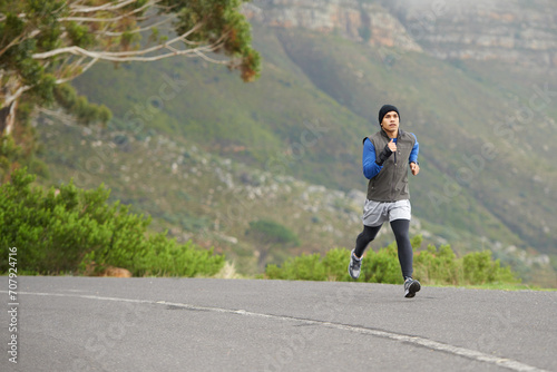 Fitness, exercise and a man in the street for running, training and marathon competition. Health, energy and a male runner or athlete in the road for sports, morning cardio or a workout in nature