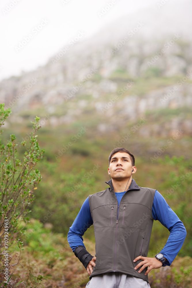 Man, hiking and earphones for music, mountain and thinking for adventure, exercise or workout. Hiker, fitness and young for training, forest and nature to explore, hobby and heart health in outdoors Man, hiking and earphones for music, mountain and thinking for adventure, exercise or workout. Hiker, fitness and young for training, forest and nature to explore, hobby and heart health in outdoors