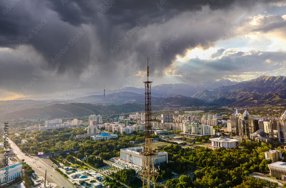 An urban landscape from a height. Aerial photography of the city of Almaty. The historical and business center of the city with mountain views.