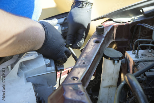 Repairman assembling vehicle headlight during car maintenance