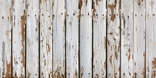 A detailed view of a wooden fence with peeling paint. This image can be used to depict weathered surfaces or as a background texture for various design projects