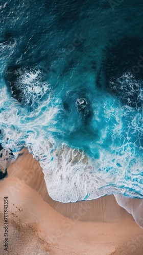 An aerial view of a sandy beach, with light blue waves and sunlit surroundings, creating a perfect backdrop for capturing the essence of vacation vibes