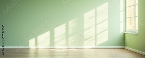 Light green wall and wooden parquet floor, sunrays and shadows from window © GalleryGlider