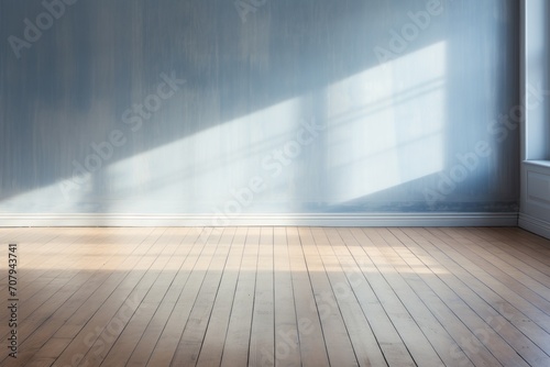 Light indigo wall and wooden parquet floor, sunrays and shadows from window photo