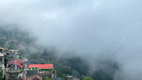 View of Darjeeling city over the a mountain in the himalayas on a cloudy day at west bengal, India. photo