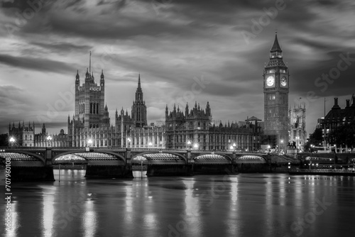 View of Westminster palace and bridge over river Thames with Big Ben illuminated at night in London, UK