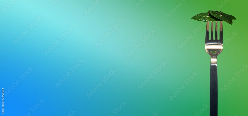 Banner with green fresh leaves picked by a fork for eating as new vegan food isolated at turquoise gradient background with copy space for text, closeup, details - obrazy, fototapety, plakaty 
