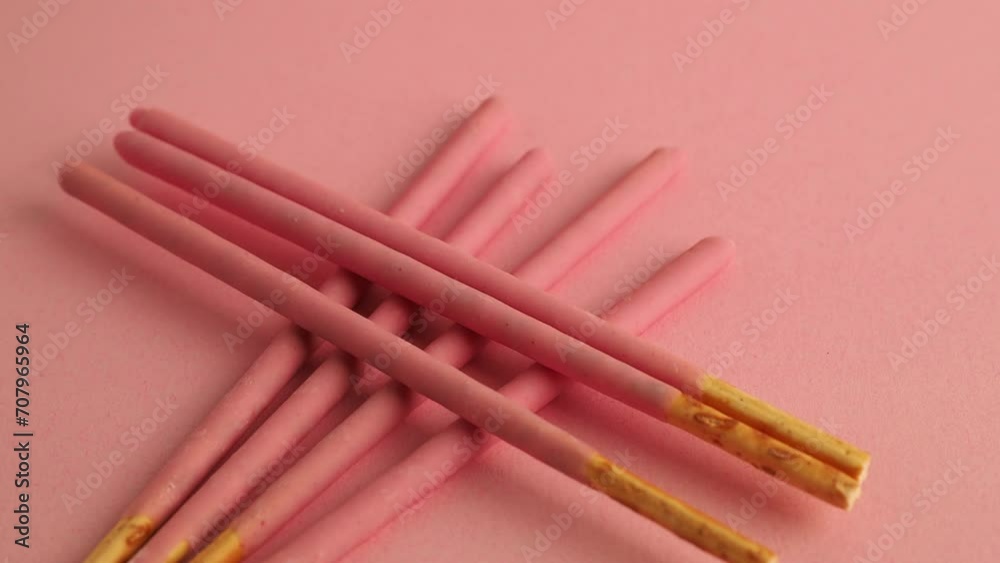 Crispy sticks in pink sugar glaze rotate on a pink background. Sticks in berry-pink glaze on a pink background. Crispy sticks in pink sugar glaze rotate on a pink background. Sticks in berry-pink glaze on a pink background.