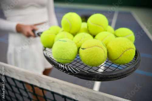 Unknown woman player holding lots tennis balls on racket © Viacheslav Yakobchuk