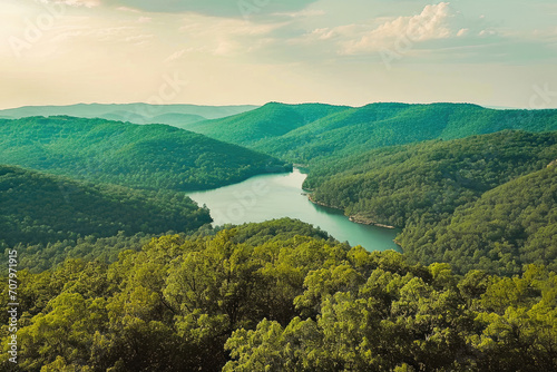 A scenic aerial view of a winding river through lush green forested mountains, depicting serenity and natural beauty.