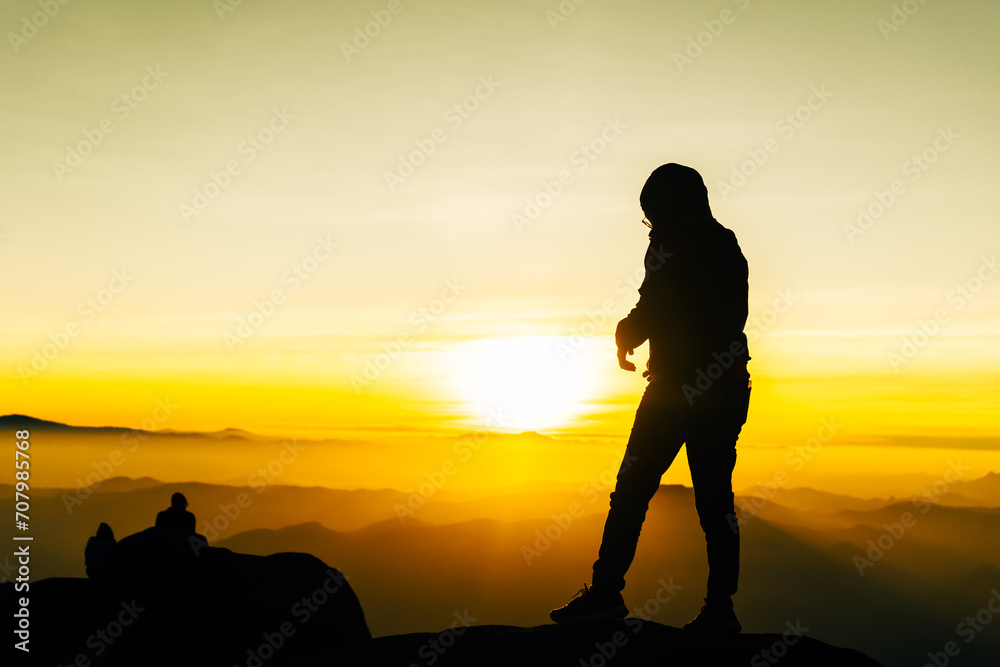 Silhouette of a hiker at mountain sunrise