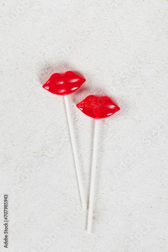 Two Red lips lollipops on a paper stick. Couple. White background. Top view. Valentine's day