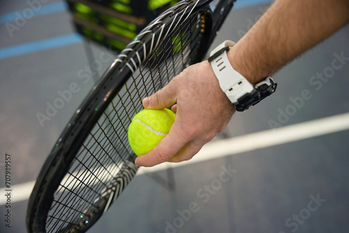 Closeup of male hand holding tennis ball and racket tennis player starting set