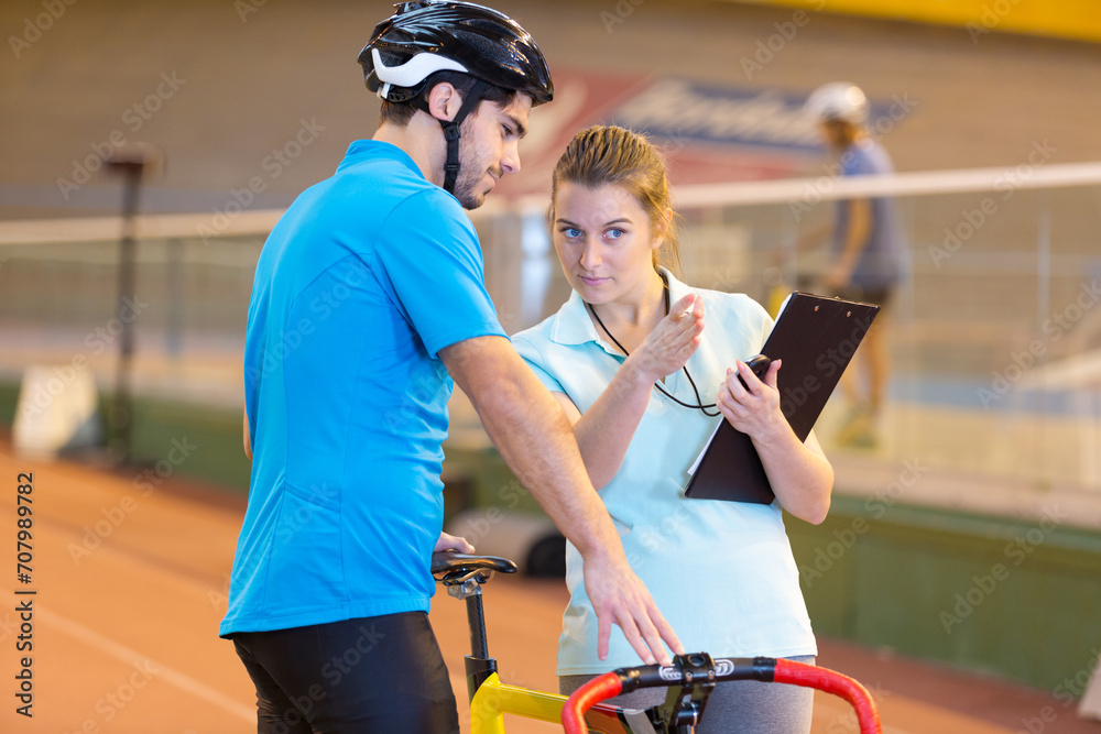 female coach with cyclist at a velodrom