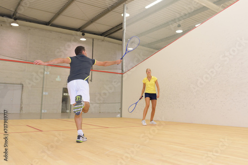 couple playing squash on indoor court