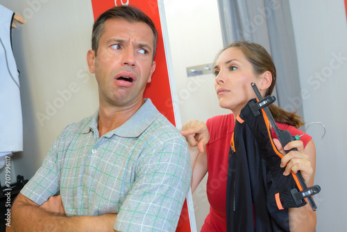 woman shopping for new clothes trying outfit with angy husband photo