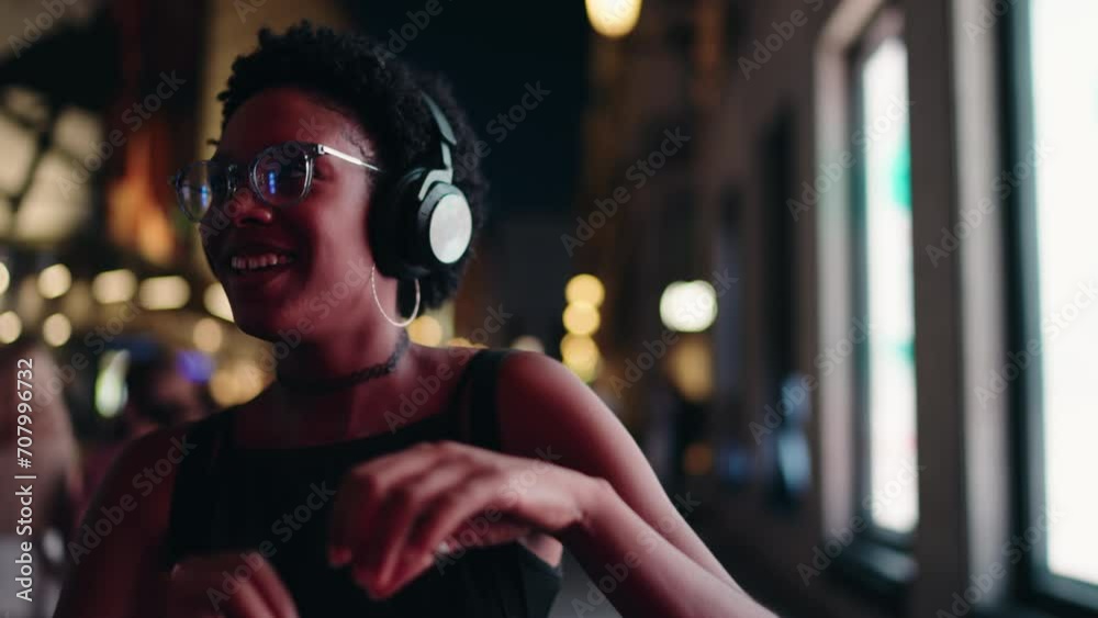African-American woman makes heart sign with her hands, savoring music and vibrant nightlife around her, with headphones accessory. Happy female dancing with Joy and love for the moment. Slow motion
African-American woman makes heart sign with her hands, savoring music and vibrant nightlife around her, with headphones accessory. Happy female dancing with Joy and love for the moment. Slow motion