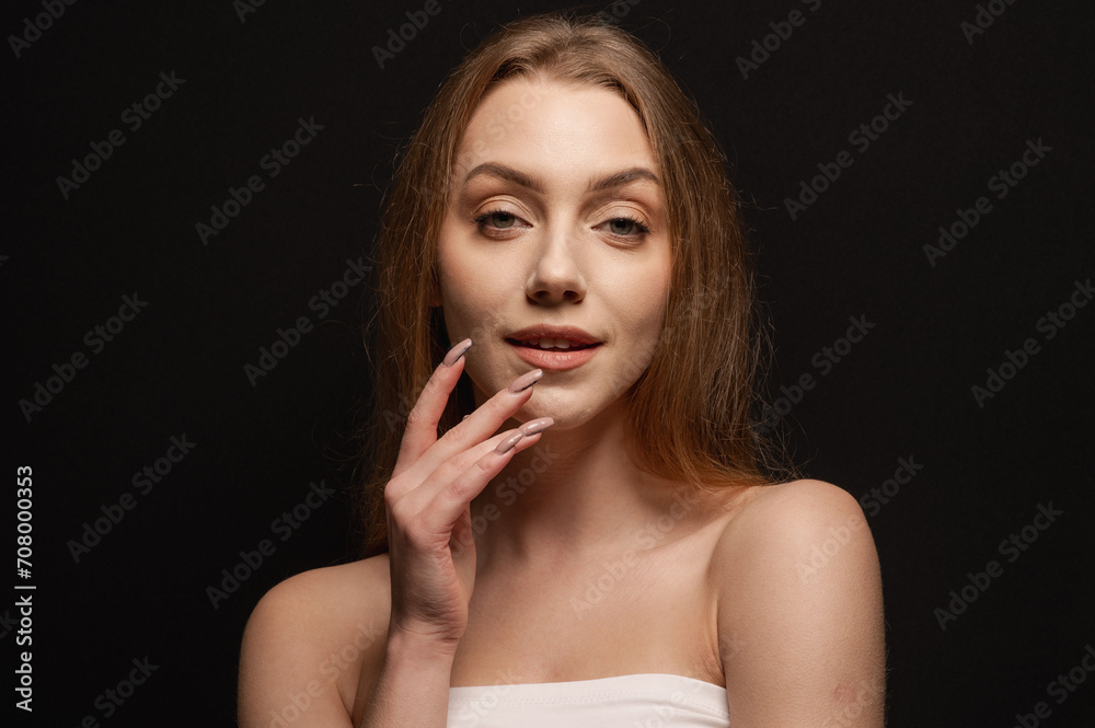 Beauty portrait of a pretty blonde girl looking tenderly against a black background Beauty portrait of a pretty blonde girl looking tenderly against a black background