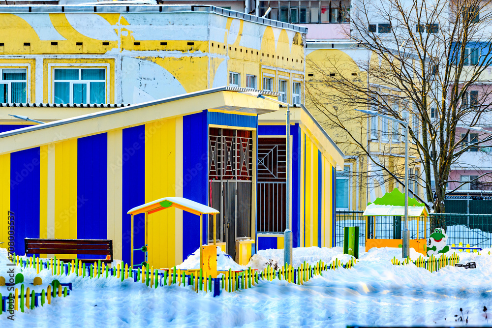 New colorful modern kindergarten building with playgrounds in snowy winter. The concept of placing a child in kindergarten on a first-come, first-served basis. - obrazy, fototapety, plakaty 