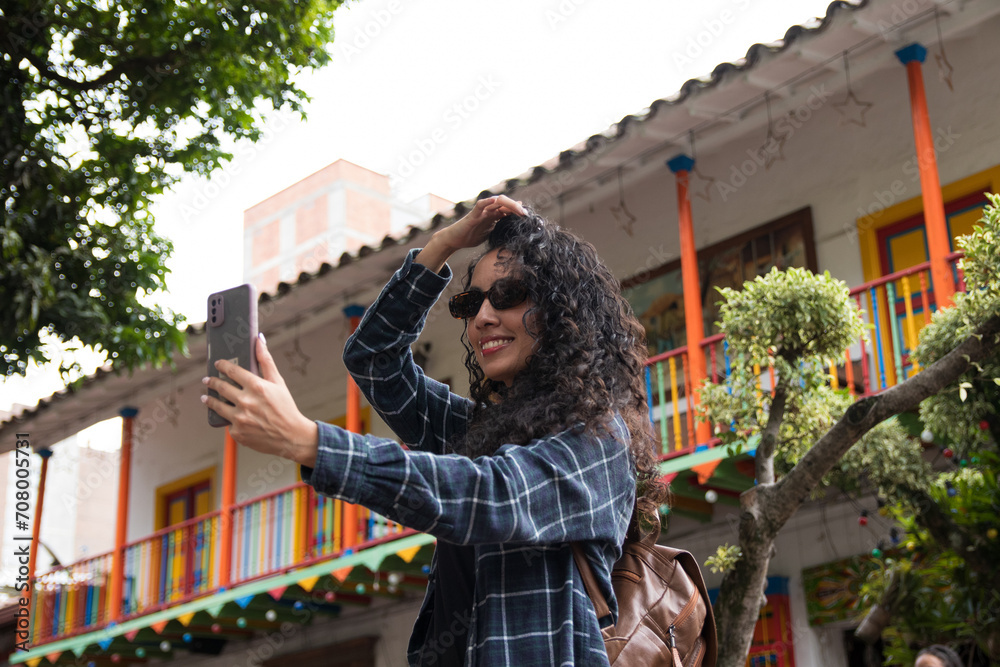 Photo of a Latin girl taking a photo with her cell phone