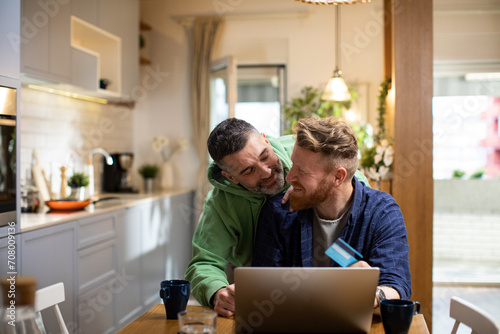 Male gay couple online shopping with laptop from home photo