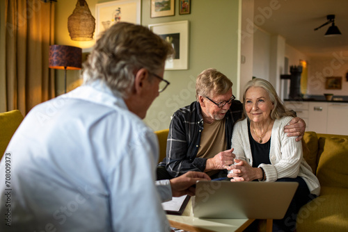 Senior Couple Consulting with Advisor at Home photo