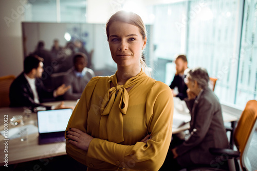 Portrait of a young businesswoman standing in busy office
