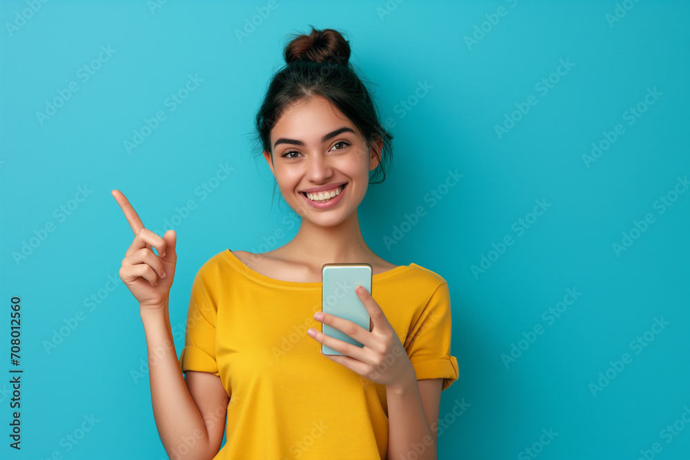 girl smiling with cell phone, raising a finger on blue background girl smiling with cell phone, raising a finger on blue background