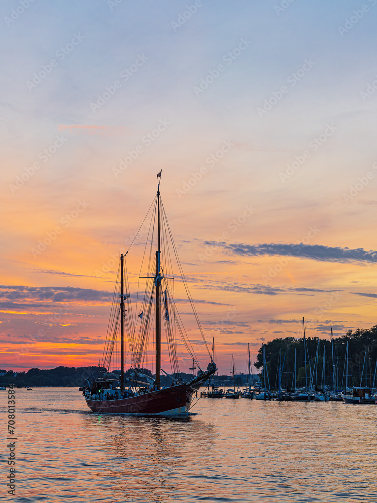 Segelschiffe auf der Warnow im Sonnenuntergang während der Hanse Sail in Rostock