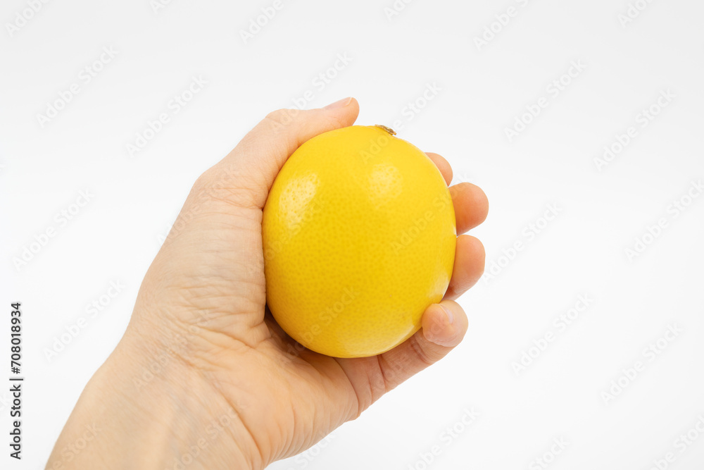 Yellow lemon in hand. Squeeze the juice from the lemon.