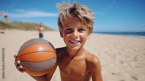 cheerful curly boy playing with a ball on the beach by the sea in summer, smiling child, happy kid, childhood, vacation, sand, emotional face, kid portrait, weekend, fun