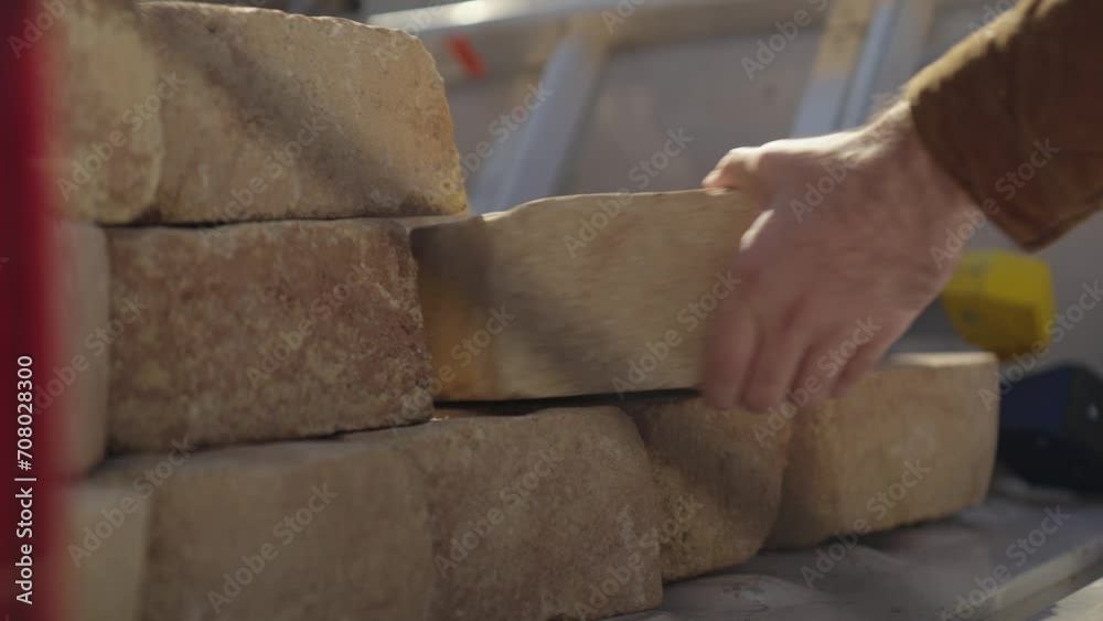 Man unloading bricks from a pickup truck and building an outdoor fire pit Man unloading bricks from a pickup truck and building an outdoor fire pit
