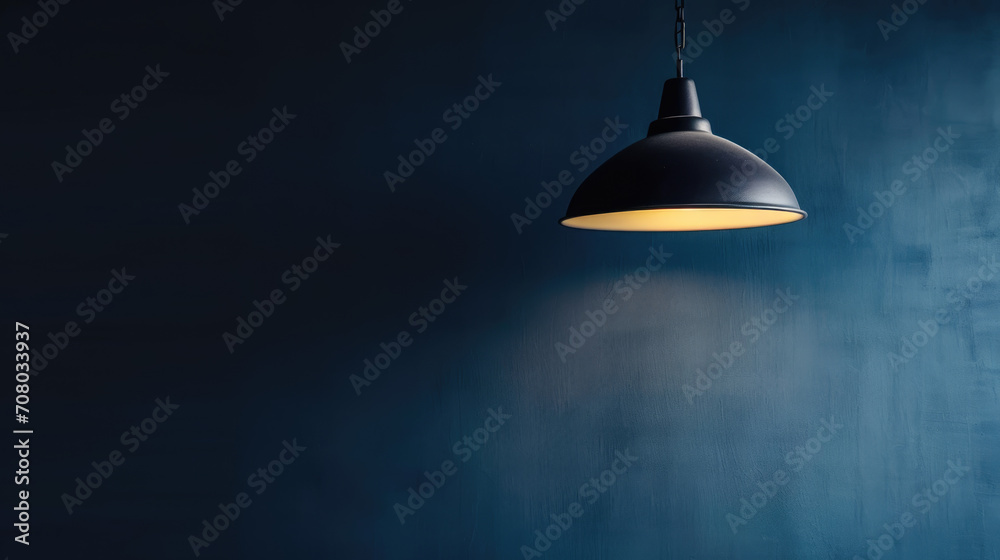 Obraz premium A lamp hangs against a dark wall, casting its light and illuminating the area, with space available for text or presentation.