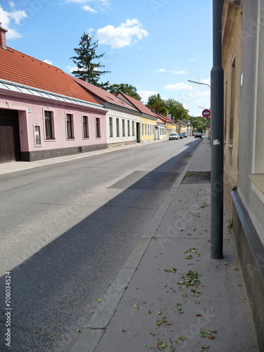 Eine Vororte-Straße in Wien mit niedrigen Häusern und wenig Verkehr. photo