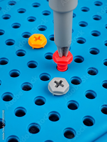 children's colorful plastic construction set, which includes an electric drill, screws, bolts and screwdrivers. various details and twisting. view from above.