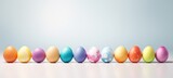Row of colored Easter eggs against a light blue background. Big Banner with copy space. Ideal for Easter promotion, spring event, holiday greeting, advertisement, festive content.