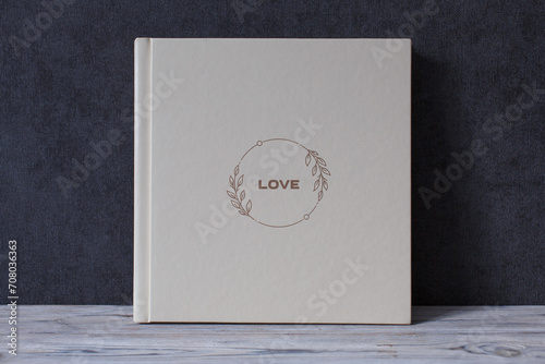 wedding or family photoalbum isolated on gray. Stylishphoto book. beige photo album with  cover  with a word love on gray background with copy space for text. pastel photo book close up portrait.  photo