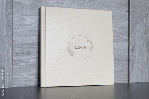 wedding or family photoalbum isolated on gray. Stylishphoto book. beige photo album with  cover  with a word love on gray background with copy space for text. pastel photo book close up portrait. 