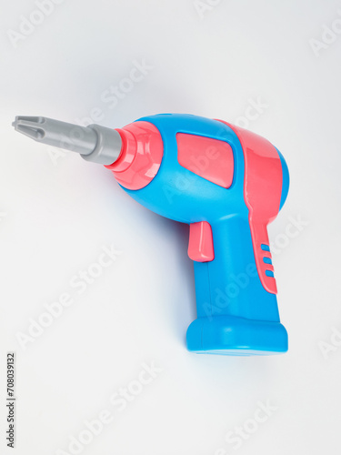 children's electric drill close-up.
children's colorful plastic construction set, which includes an electric drill, screws, bolts and screwdrivers.