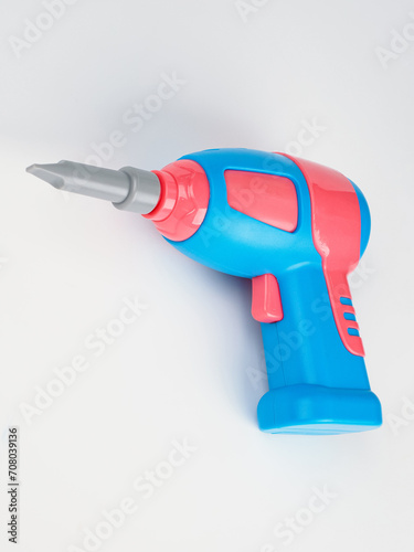 children's electric drill close-up.
children's colorful plastic construction set, which includes an electric drill, screws, bolts and screwdrivers.