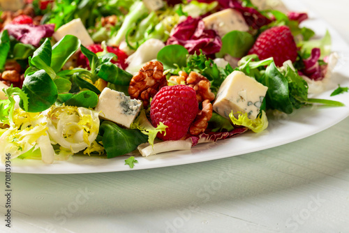 Salad with blue cheese, raspberries and walnuts.