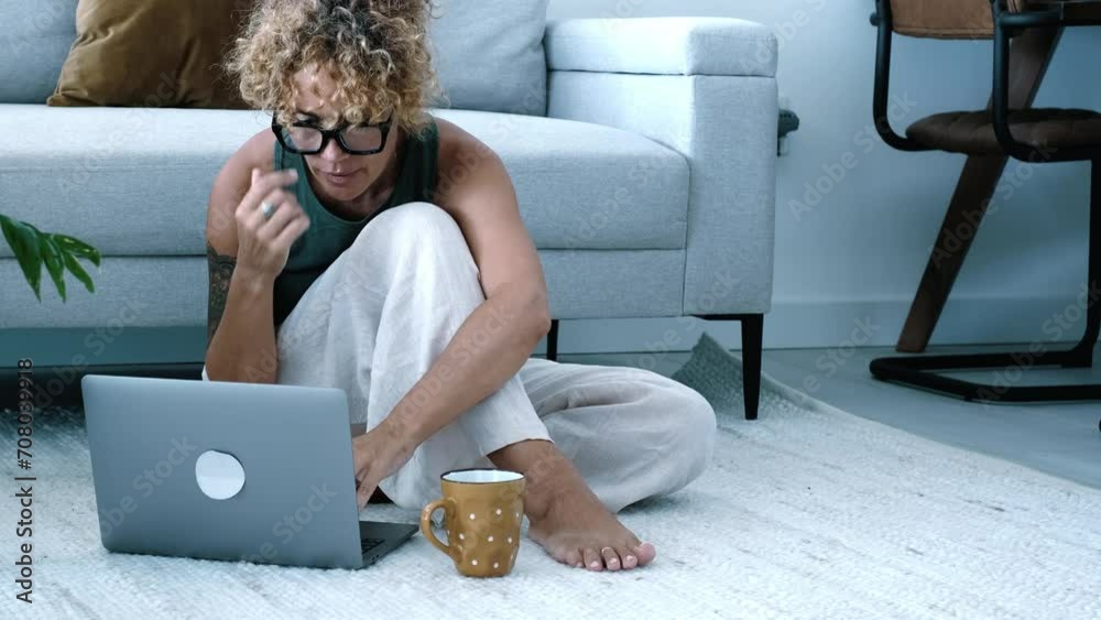 One woman using laptop computer sitting on the floor at home in modern indoor leisure activity alone. Smart working and searching on web concept people lifestyle. Trendy female use notebook indoor