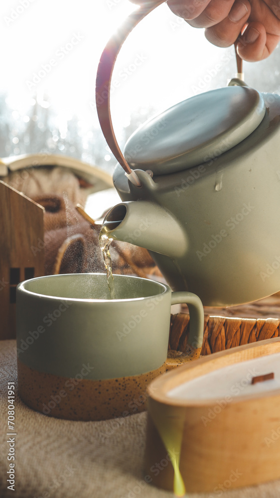 Pouring a cup of tea, cozy home photo