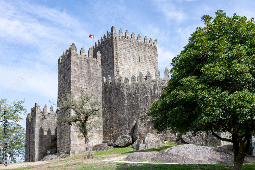 Guimaraes Castle in Guimaraes, Portugal, a hilltop Romanesque castle, founded in the 1000s and birthplace of Afonso Henriques against a clear blue sky